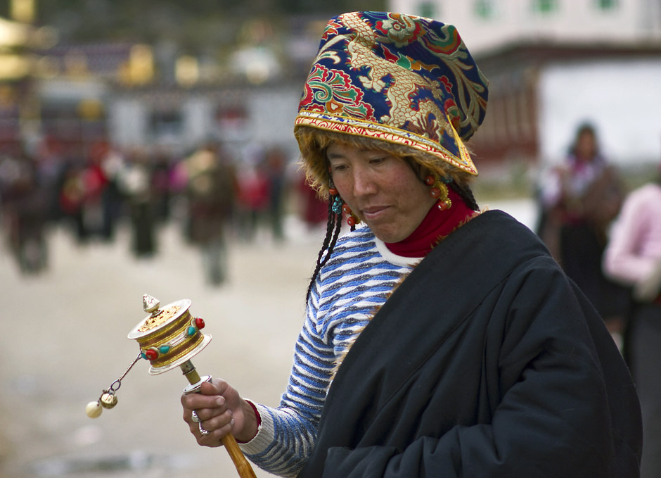 16. CHINY, Dzogchen Gompa. Tybetańska kobiety rzadko odkładają swoje młynki modlitewne, które często są dziełami sztuki, wykonanymi z metali szlachetnych i ozdobionymi koralami i turkusami. (Fot. Magda Świder) 16. CHINY, Dzogchen Gompa. Tybetańska kobiety rzadko odkładają swoje młynki modlitewne, które często są dziełami sztuki, wykonanymi z metali szlachetnych i ozdobionymi koralami i turkusami. (Fot. Magda Świder)