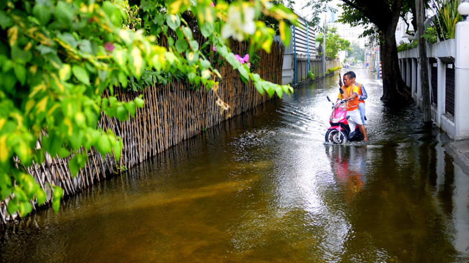9. TAJLANDIA, Bangkok. Zalane boczne uliczki nie pustoszeją całkowicie. Tu, kierowca motocyklowej taksówki z kolegą wybrali się na ryby. (Fot. Maciej Klimowicz) Powódź w Bangkoku - fotoreportaż