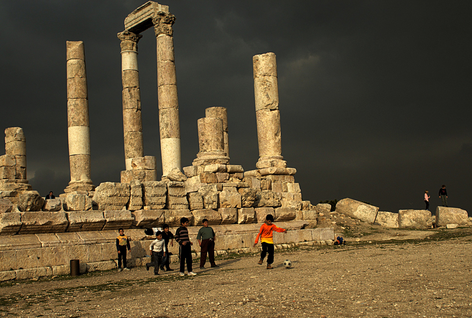 2. JORDANIA, Amman, grudzień 2013. Początek zwiedzania (minimum trzydniowego, bez względu na środek lokomocji) warto zaplanować od zobaczenia miasta z góry - ze Wzgórza Cytadeli, na której znajdują się oczywiście ruiny cytadeli, ale także świątynia Heraklesa. Tuż przyniej, niemal codziennie, rozgrywane są mecze piłkarskie - trudno sobie wyobrazić sytuację, by w Polsce udostępnić zwiedzającym podobny zabytek, jednocześnie udstępniając go dziecakom do gry w gałę! Widać stamtąd miasto rozłożonie nisko na okolicznych wzniesieniach. Teatr Rzymski, Wzgórze Flagowe, Abdali z wieżowcami... (Fot. Norbert Skrzyński) Zabytki w Ammanie - stolicy Jordanii